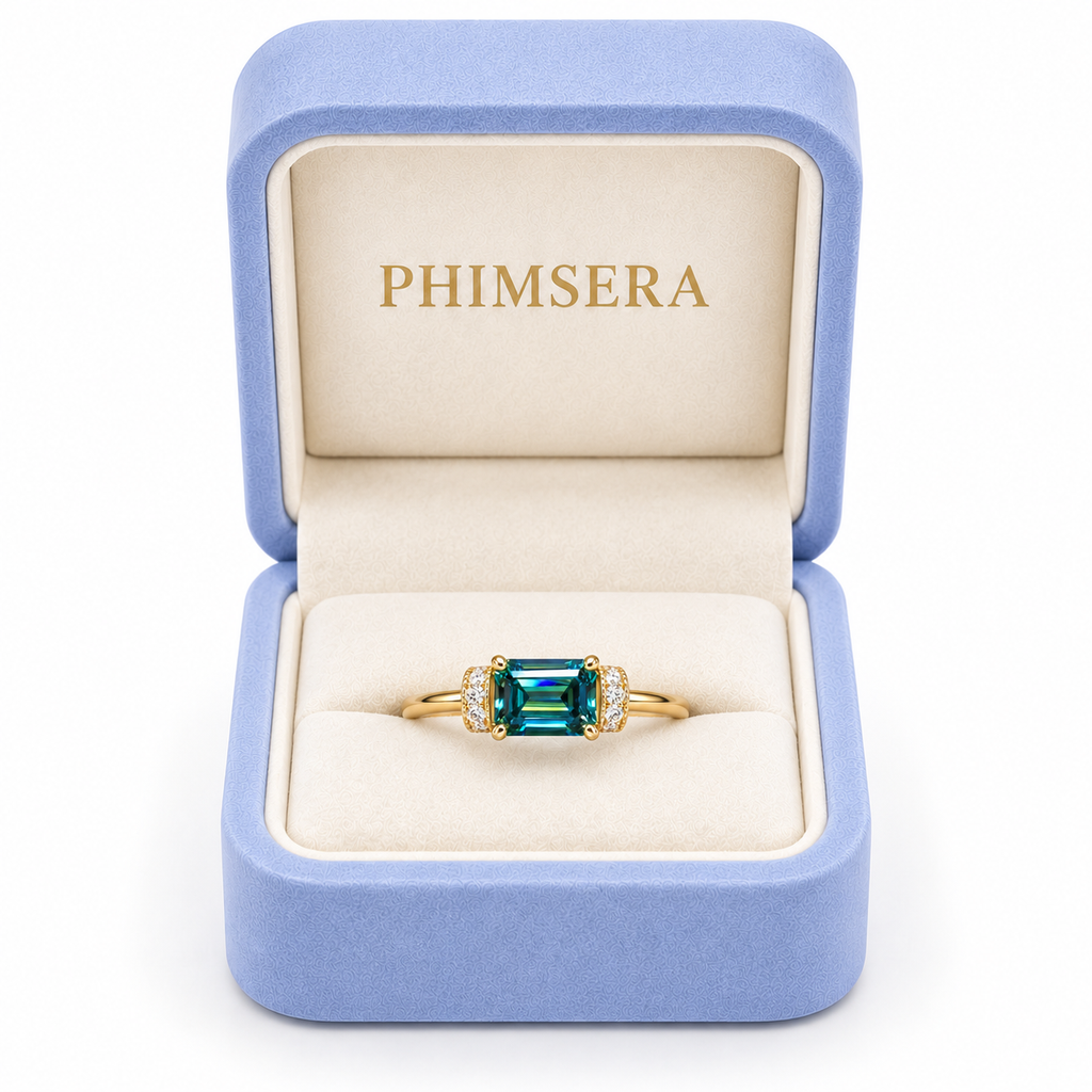 1 Carat Emerald Cut Green Moissanite Ring Measuring 5x7mm in a Phimsera Box with a white background.