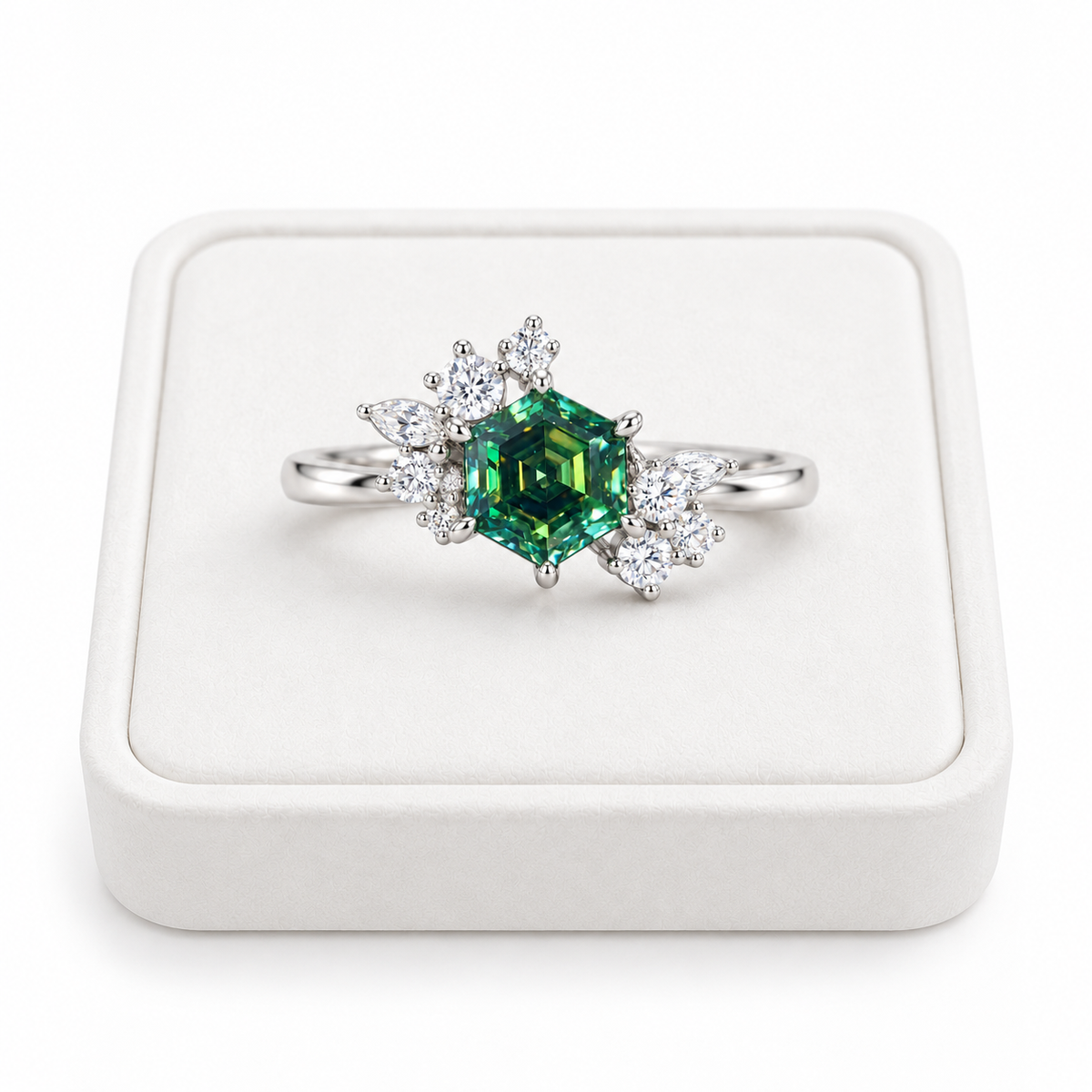 1 carat green moissanite hexagon ring displayed on a flat white velvet jewelry tray against a pure white background, featuring a 6mm lab-created gemstone with emerald-green and teal reflections and sparkling floral cubic zirconia accents.