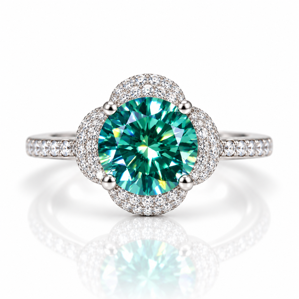 2 carat 8mm round brilliant-cut lab-created green moissanite ring featuring a vibrant teal-green center gemstone, four-petal floral cubic zirconia halo, four-prong setting, and sparkling 925 sterling silver band on a pure white background.