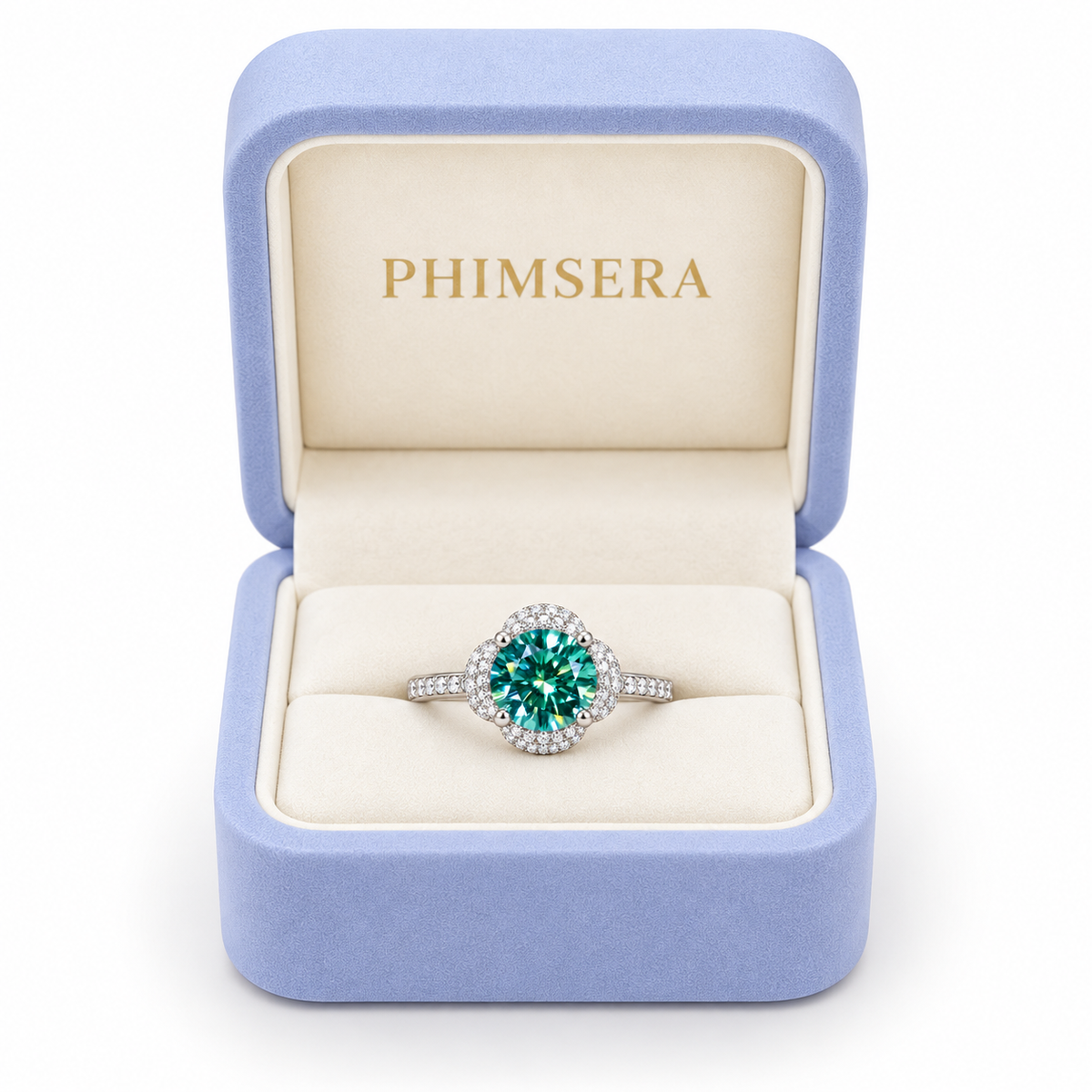 2 carat 8mm round brilliant green moissanite floral halo ring displayed inside a periwinkle Phimsera jewelry gift box with an ivory interior and gold PHIMSERA lettering, showcasing the vibrant teal-green gemstone, sparkling cubic zirconia floral halo, and polished sterling silver band against a white background.