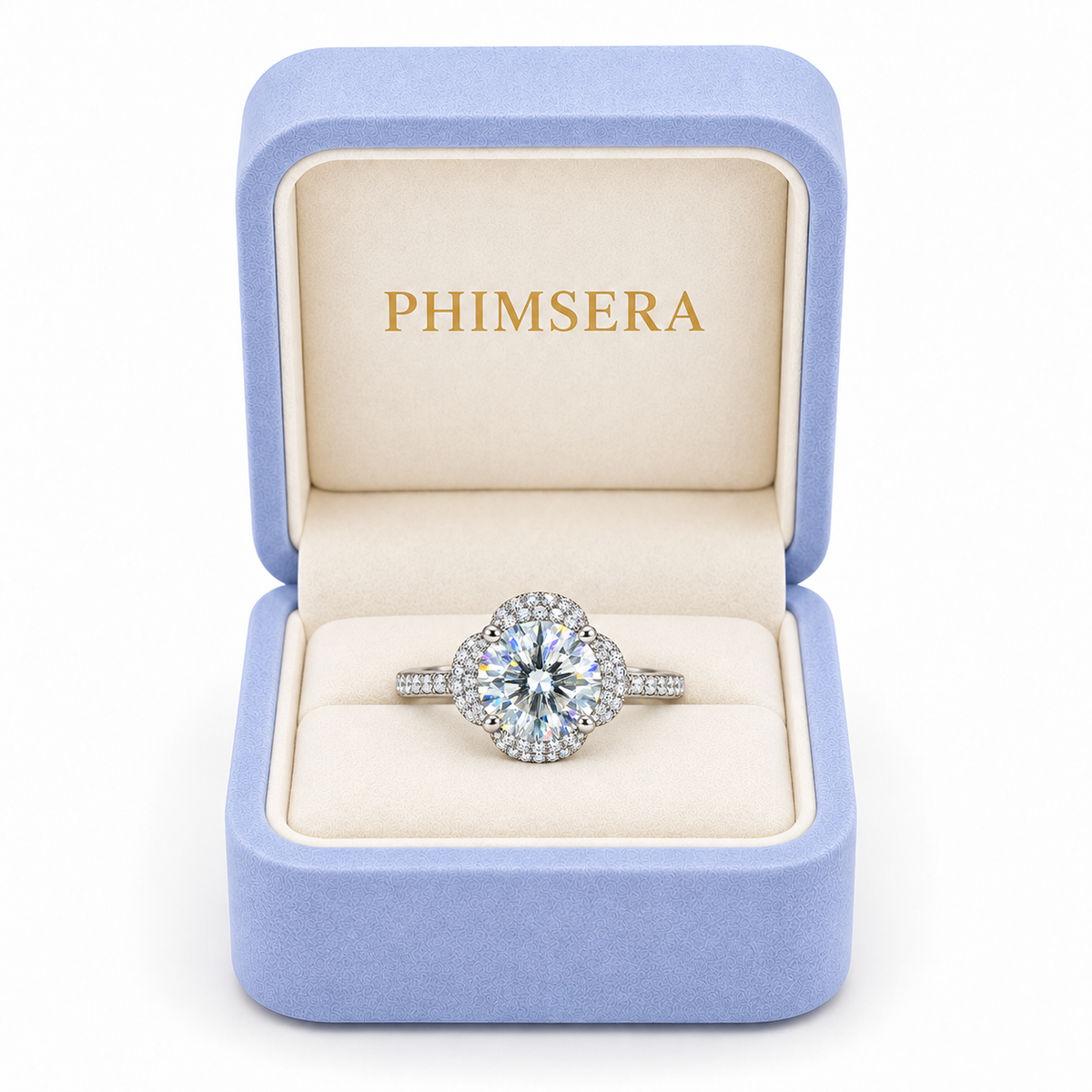 2 carat white moissanite floral halo ring presented inside a periwinkle Phimsera jewelry gift box with ivory interior and gold PHIMSERA lettering against a clean white background.