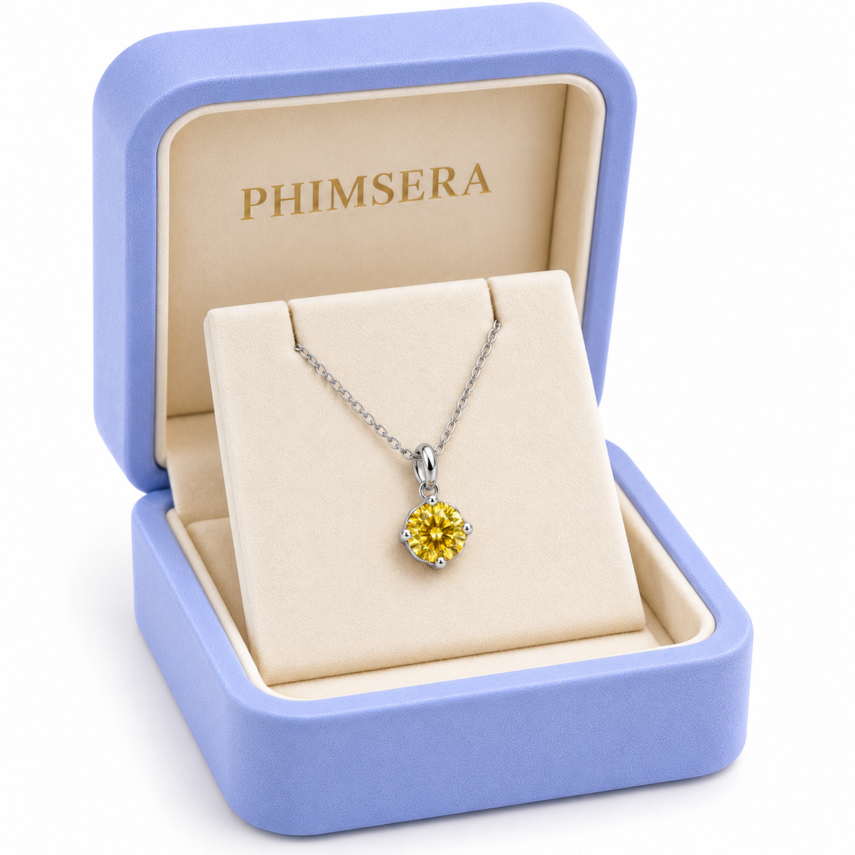 Angled view of a periwinkle Phimsera jewelry gift box containing an 8mm golden-yellow moissanite solitaire pendant necklace with a delicate silver chain, ivory jewelry insert, and gold Phimsera branding.