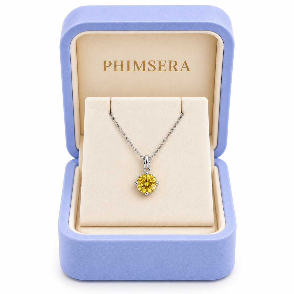 2 carat yellow moissanite solitaire necklace displayed inside an open periwinkle Phimsera jewelry gift box with an ivory interior, gold Phimsera logo, and elegant white background.