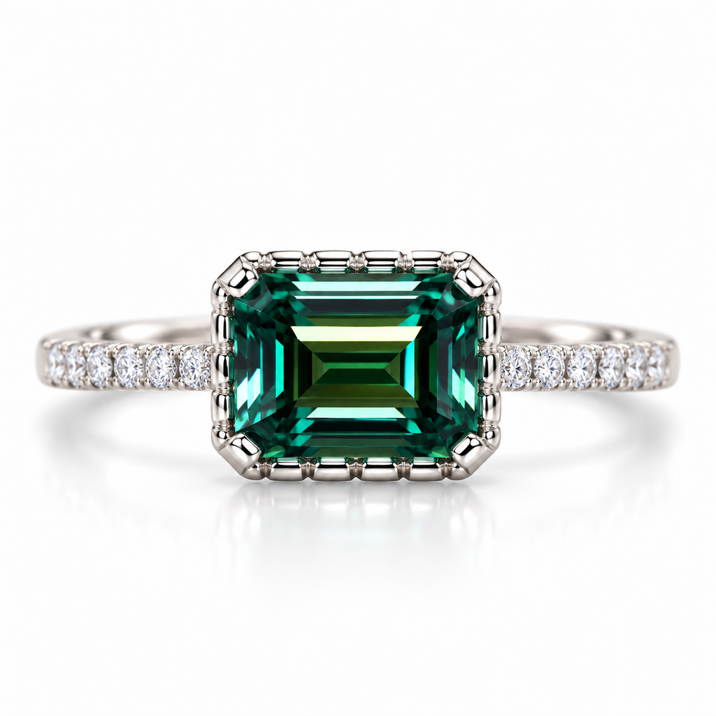 2 carat lab-created green moissanite ring featuring a horizontally set 6x8mm emerald-cut gemstone with deep forest-green and teal reflections, four-prong setting, and cubic zirconia accents in Platinum Plated 925 sterling silver on a white background.