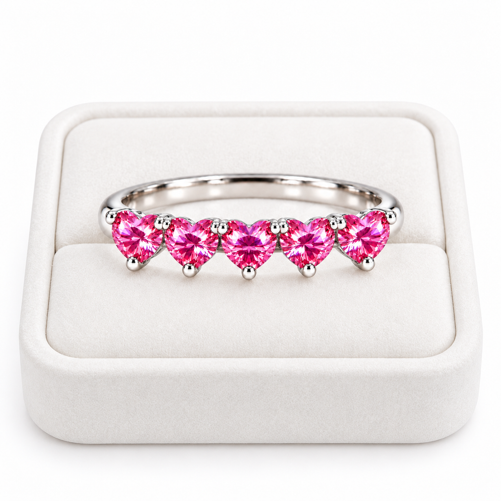 Five 4mm heart-cut pink moissanite ring displayed on a white velvet jewelry tray