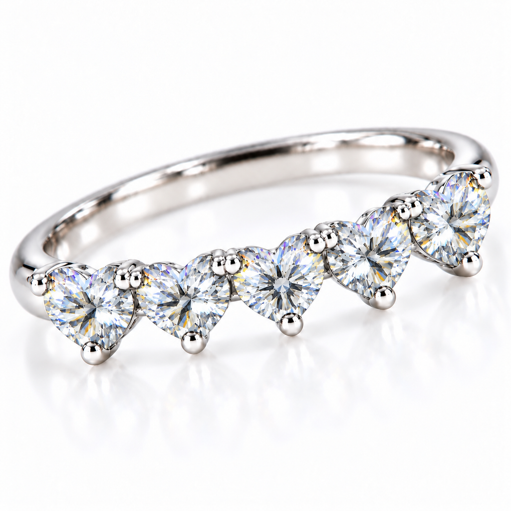 Angled view of five matching 4mm heart-cut white moissanite stones on a curved silver ring