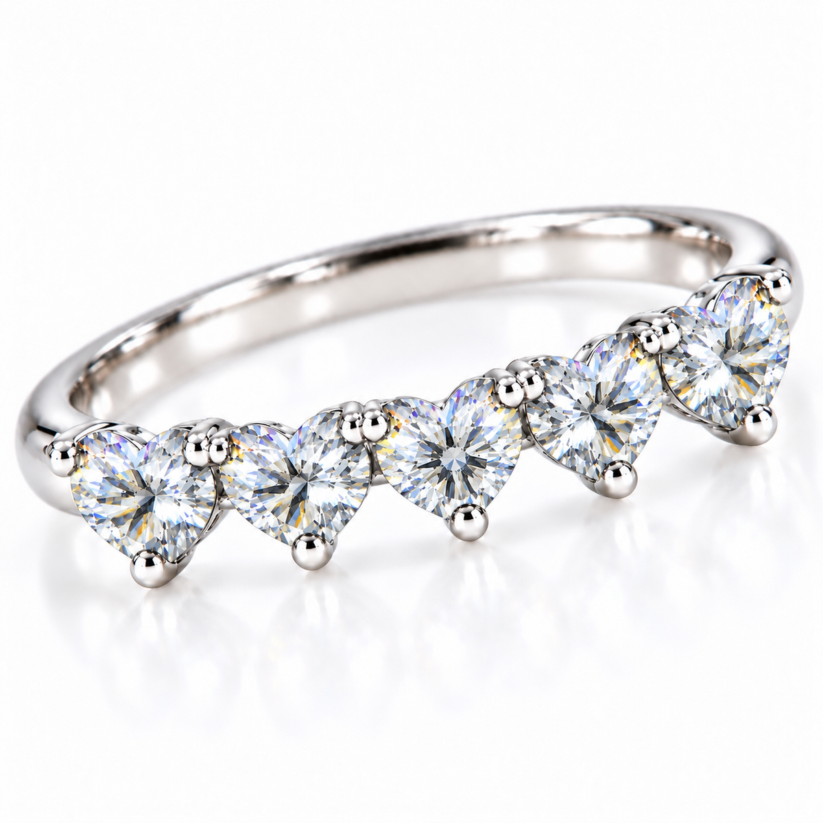 Angled view of five matching 4mm heart-cut white moissanite stones on a curved silver ring