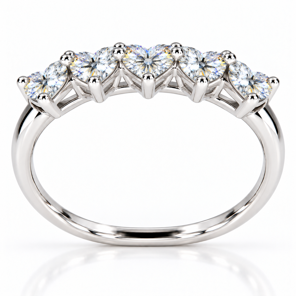 Elevated view of five 4mm heart-cut white moissanite gemstones on a sterling silver ring