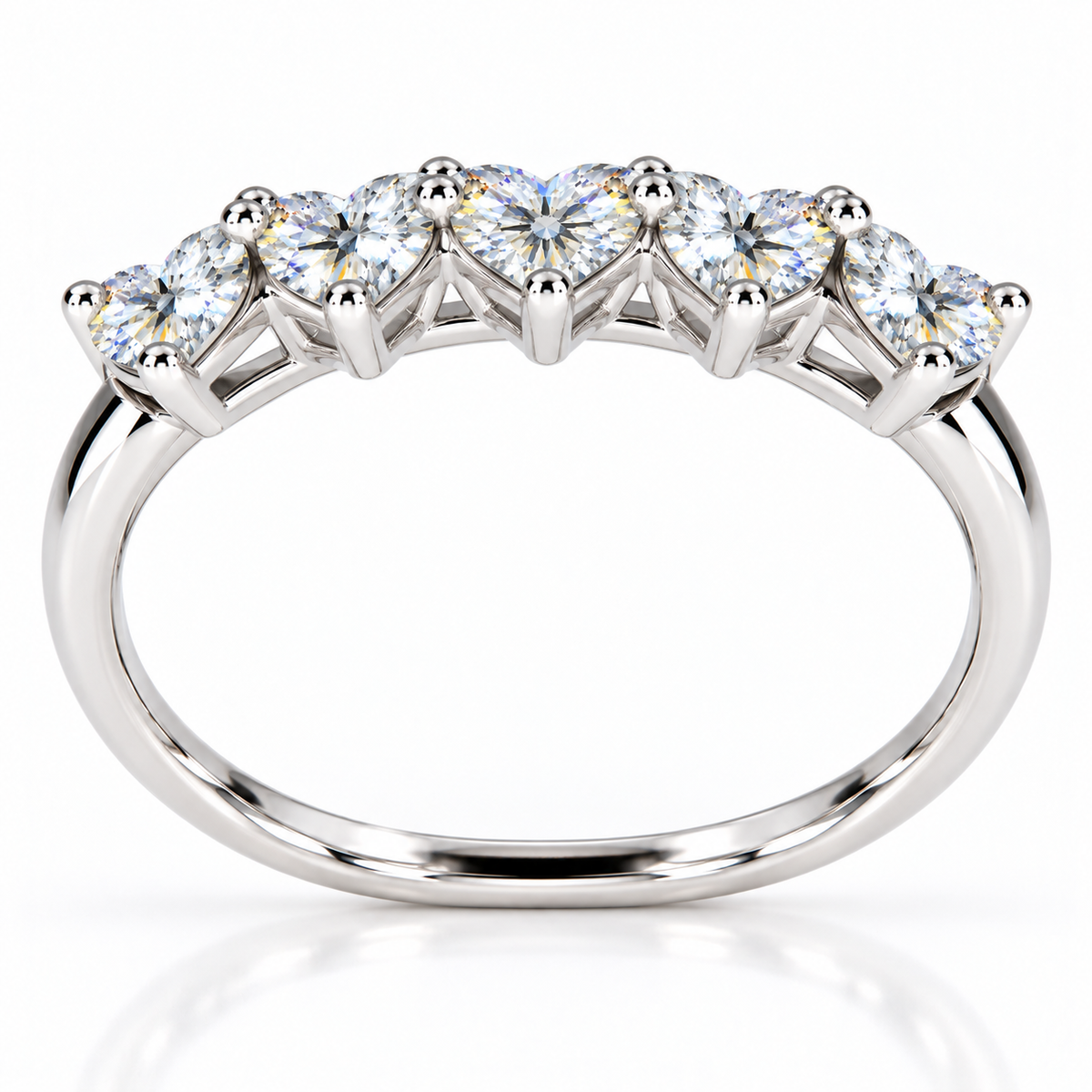 Elevated view of five 4mm heart-cut white moissanite gemstones on a sterling silver ring