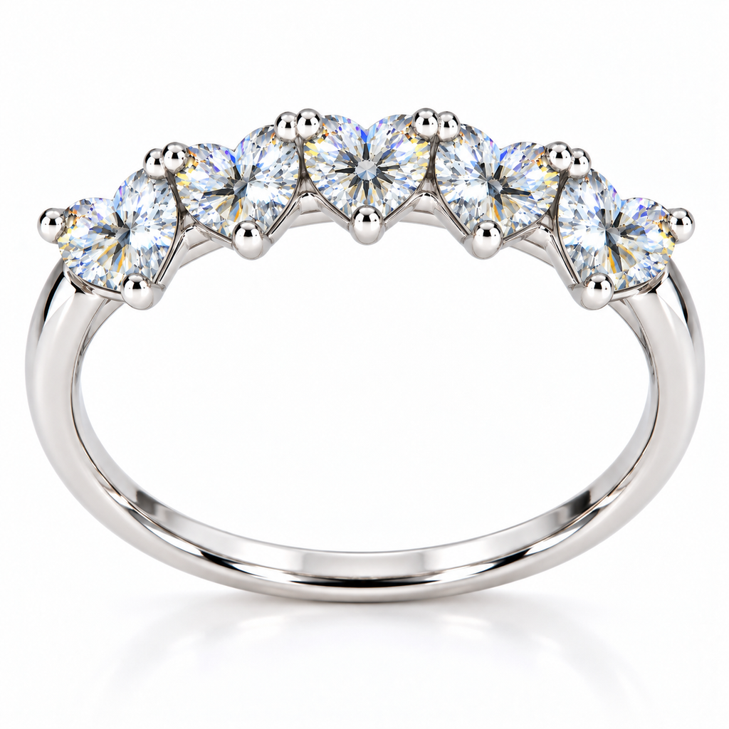 Side view of five matching 4mm heart-cut white moissanite gemstones on a curved silver ring