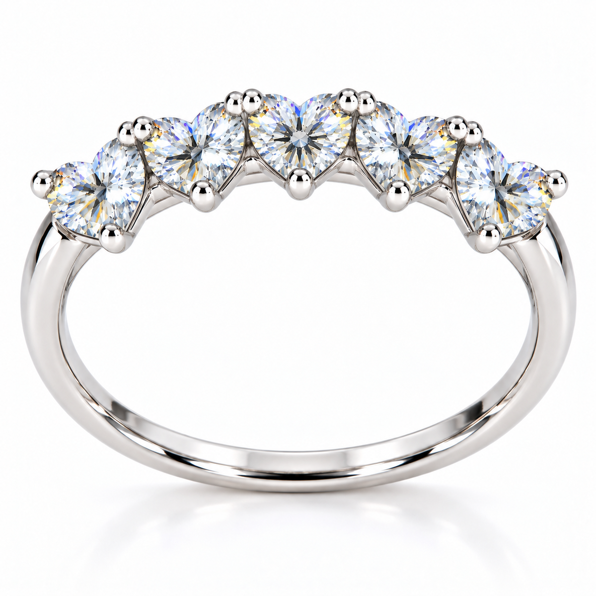 Side view of five matching 4mm heart-cut white moissanite gemstones on a curved silver ring