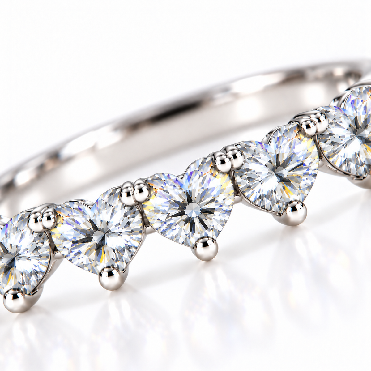 Close-up of five 4mm heart-cut white moissanite gemstones with brilliant faceting