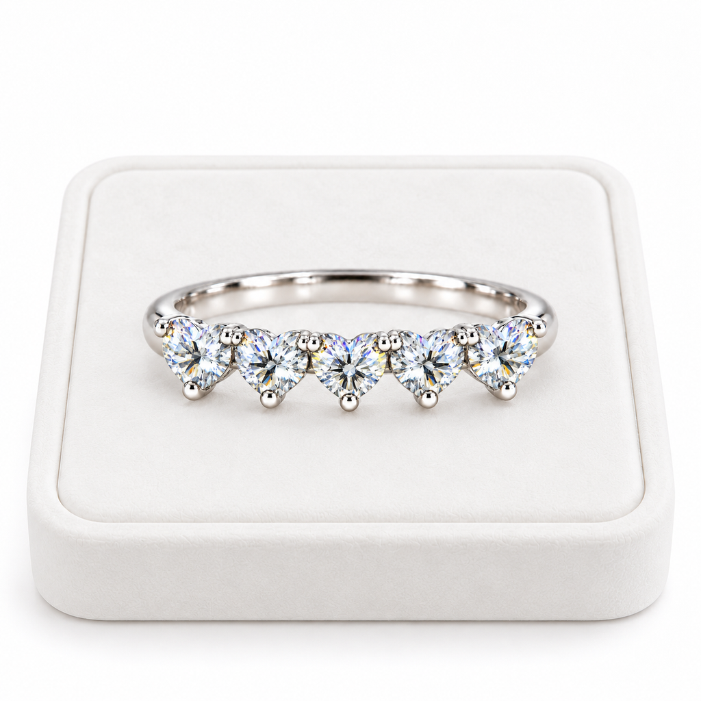 Five 4mm heart-cut white moissanite ring displayed on a white velvet jewelry tray