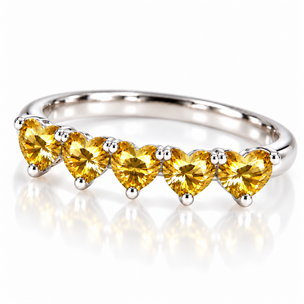 Angled view of five matching 4mm heart-cut yellow moissanite gemstones on a curved silver ring