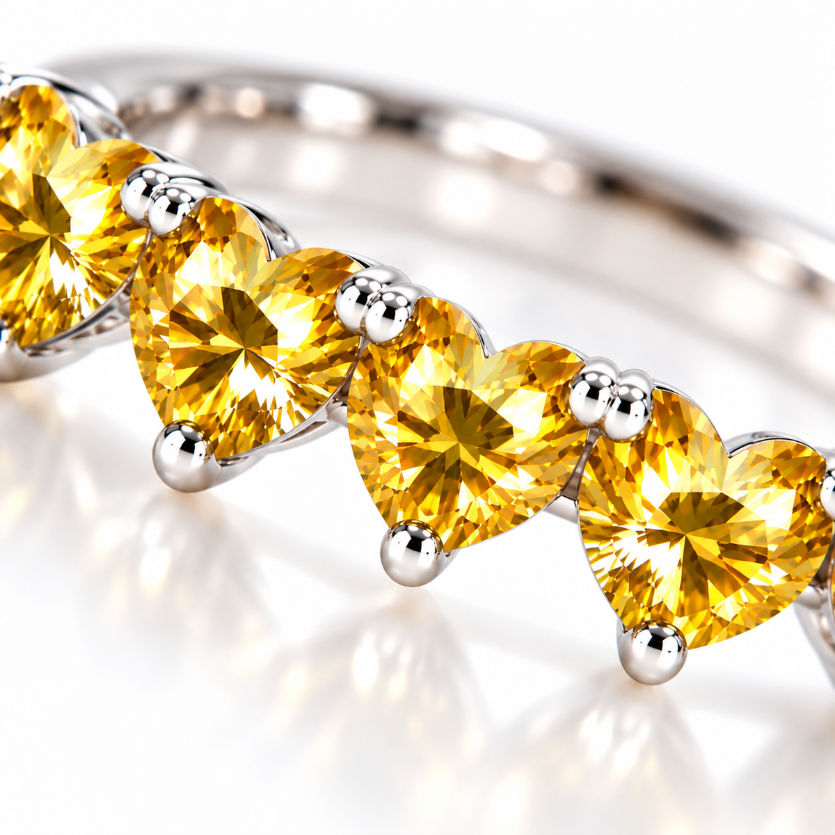 Macro close-up of five 4mm heart-cut yellow moissanite gemstones showing golden-yellow faceting and silver prongs
