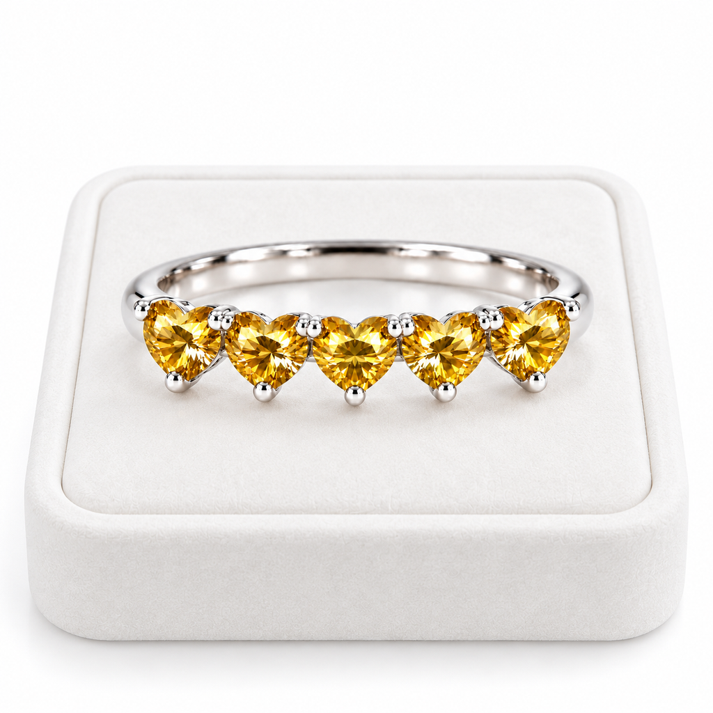 Five 4mm heart-cut yellow moissanite ring displayed on a white velvet jewelry tray