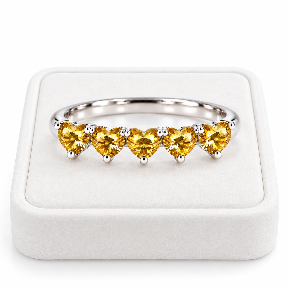 Five 4mm heart-cut yellow moissanite ring displayed on a white velvet jewelry tray