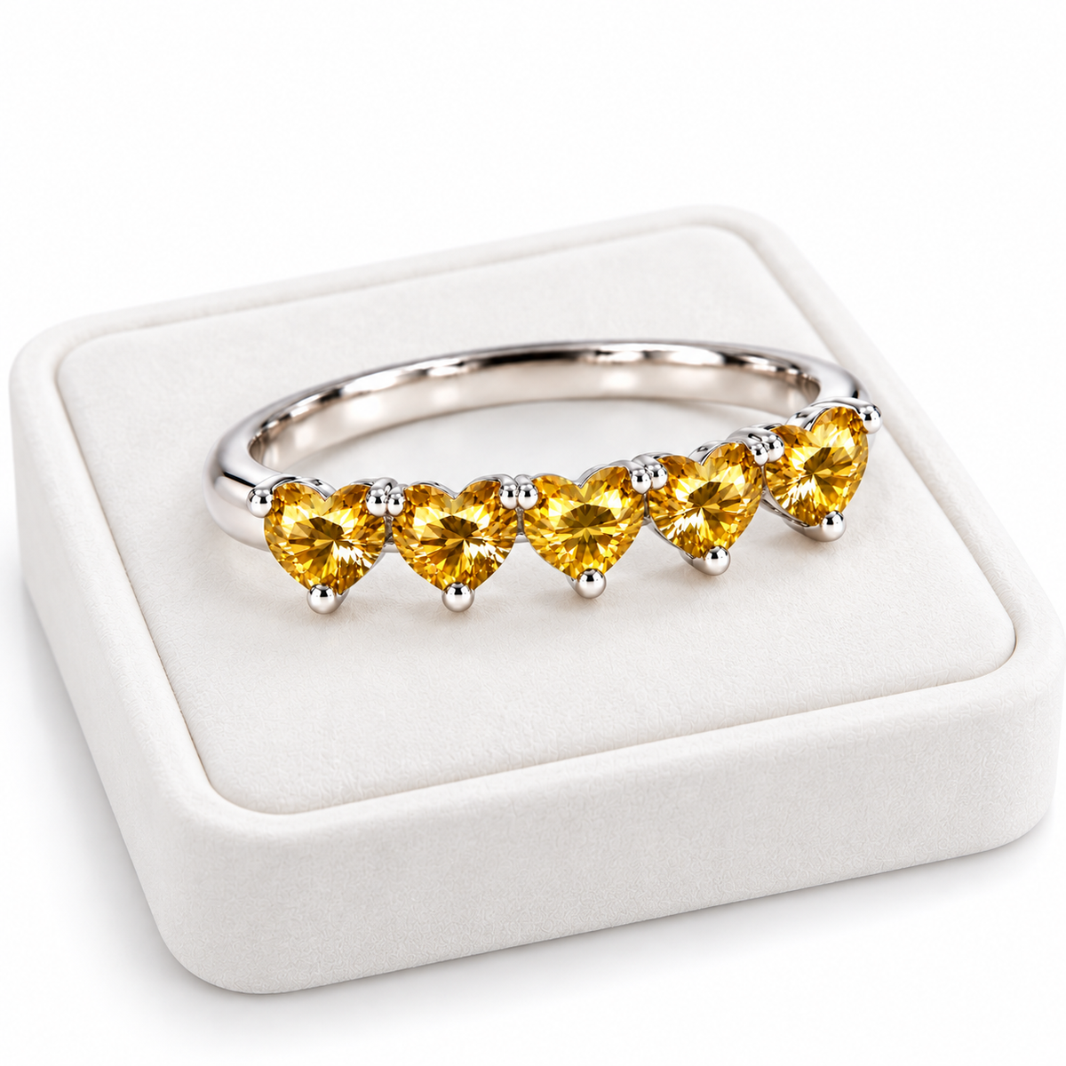 Angled five-heart yellow moissanite ring displayed on a white velvet jewelry tray