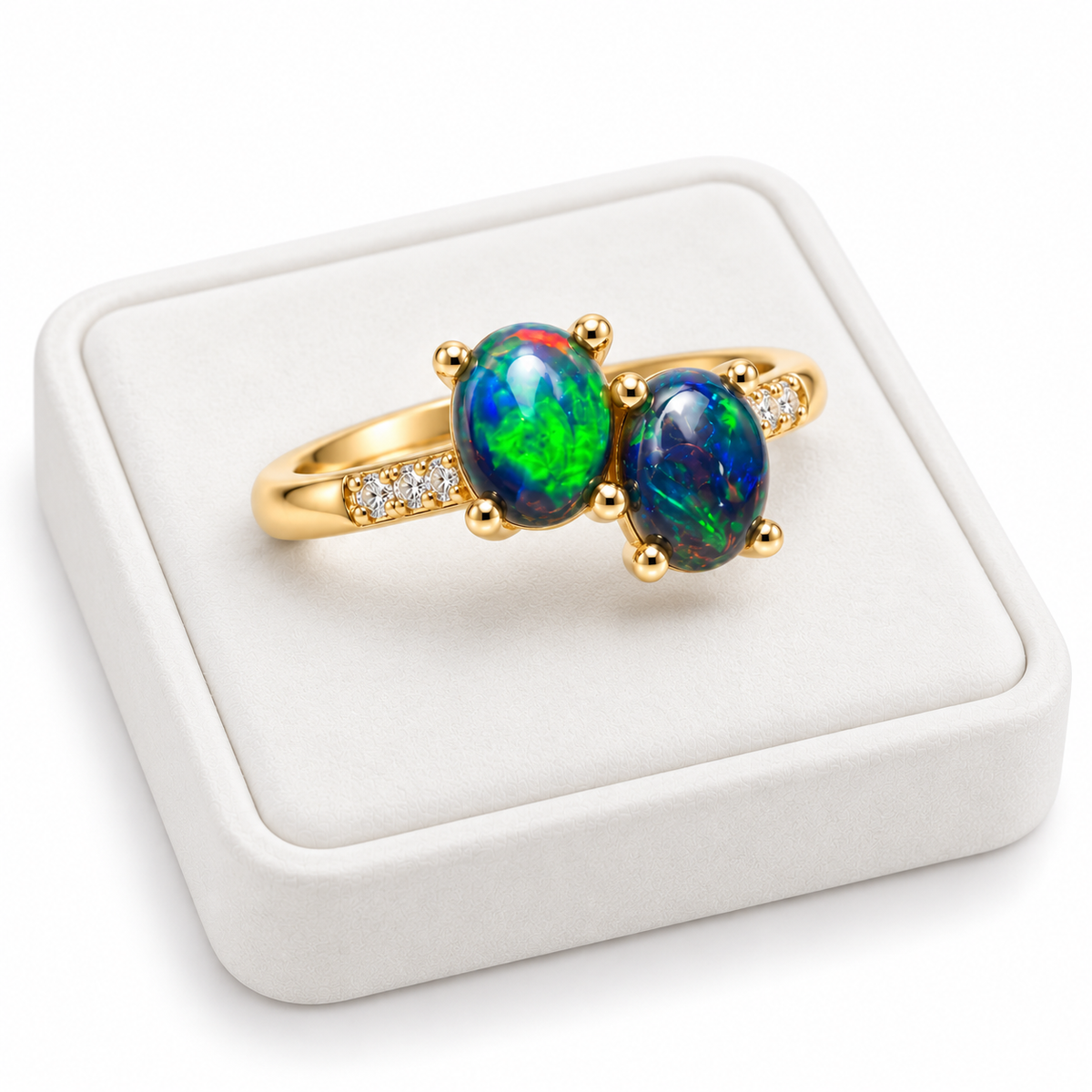 Black fire opal two-stone ring with oval gemstones displayed on a flat white velvet jewelry tray against a bright white background.
