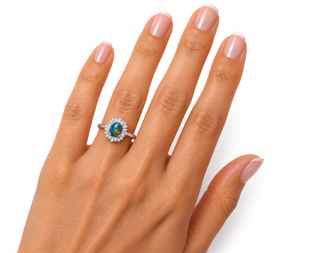 Black opal sunburst halo ring worn on a woman's ring finger, showing realistic 5x7mm oval gemstone proportions, sparkling cubic zirconia halo, and polished silver-colored band.