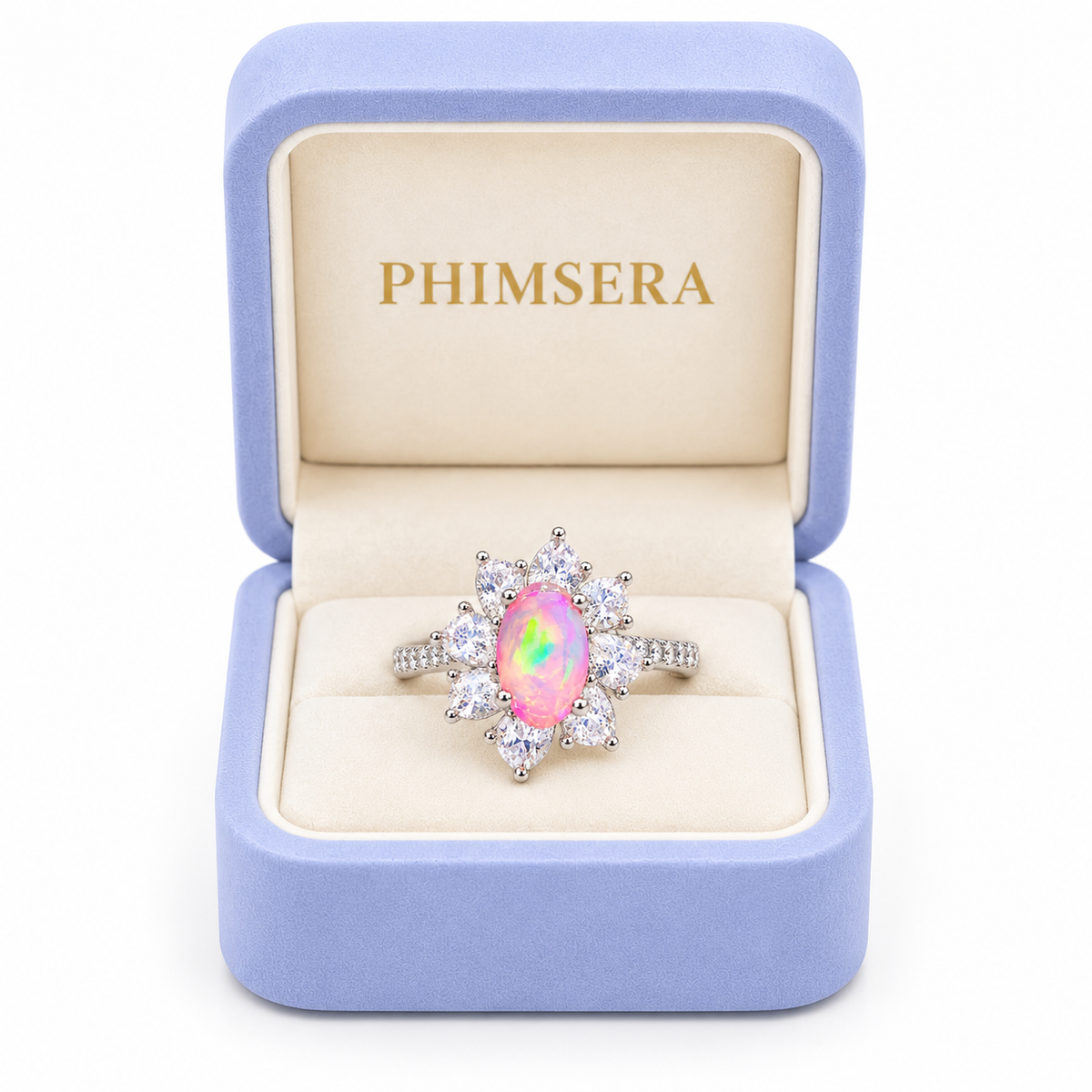 Australian pink fire opal flower ring displayed inside a periwinkle Phimsera jewelry box with cream velvet interior and gold PHIMSERA lettering, featuring a 5x8mm oval pink gemstone and sparkling floral halo.