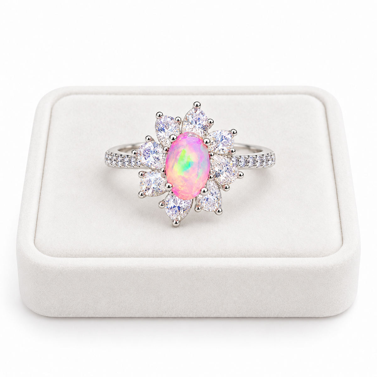 Australian pink fire opal flower ring featuring a 5x8mm oval gemstone displayed on a flat white velvet jewelry tray against a clean white background, showcasing the floral cubic zirconia halo.