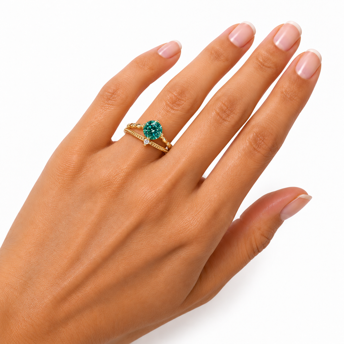 Angled close-up of a woman's hand wearing a 6.5mm round brilliant green moissanite ring, highlighting the gemstone's vivid teal-green brilliance, four polished gold-tone prongs, and elegant vine-inspired Gold Plated sterling silver band.