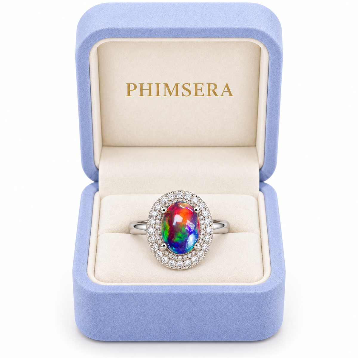 Australian black fire opal halo ring with a 6x8mm oval gemstone displayed inside a periwinkle Phimsera jewelry box with cream velvet interior and gold PHIMSERA lettering.