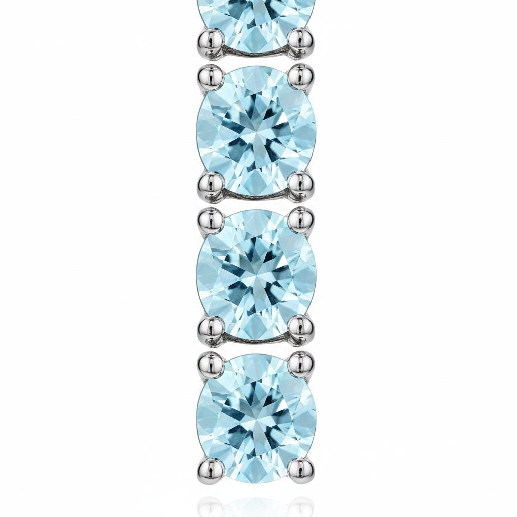 Macro view of 3mm round blue aquamarine gemstones in Phimsera sterling silver dangle earrings