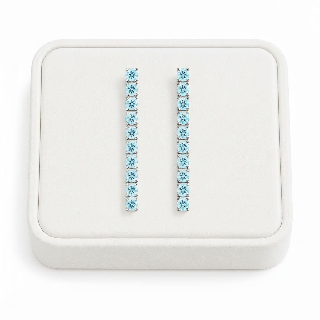Phimsera natural aquamarine dangle earrings displayed on a white velvet jewelry tray against a bright white background