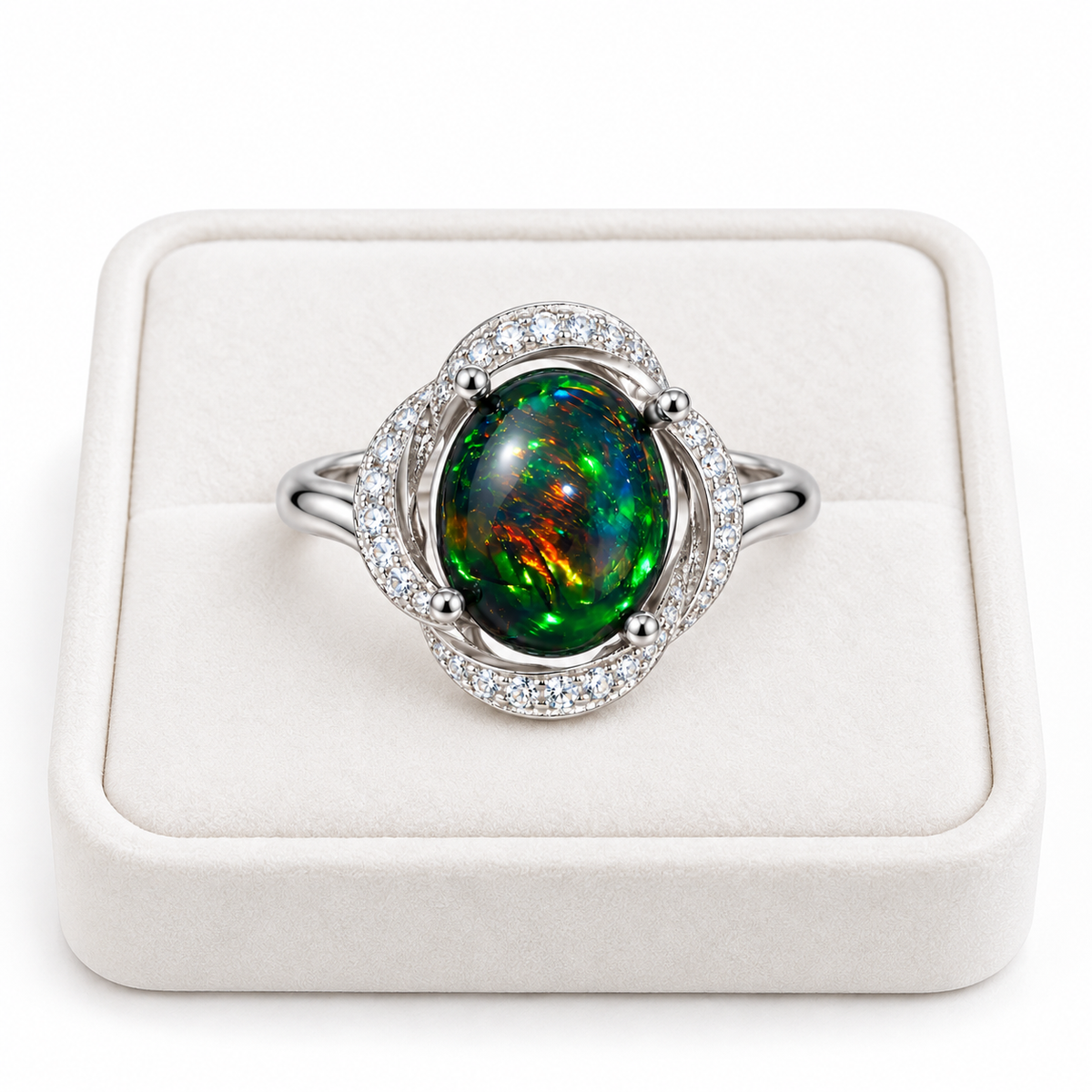 8x10mm Australian fire opal dyed black with colorful green, blue, and orange flashes in a silver-colored halo ring displayed on a white velvet tray.