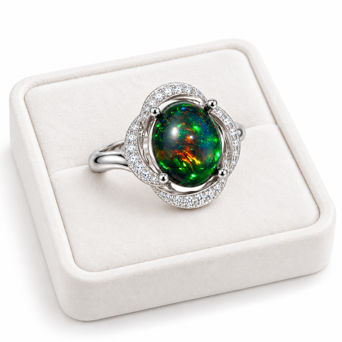 8x10mm Australian fire opal dyed black with colorful green, blue, and orange flashes in a silver-colored halo ring displayed on a white velvet tray.