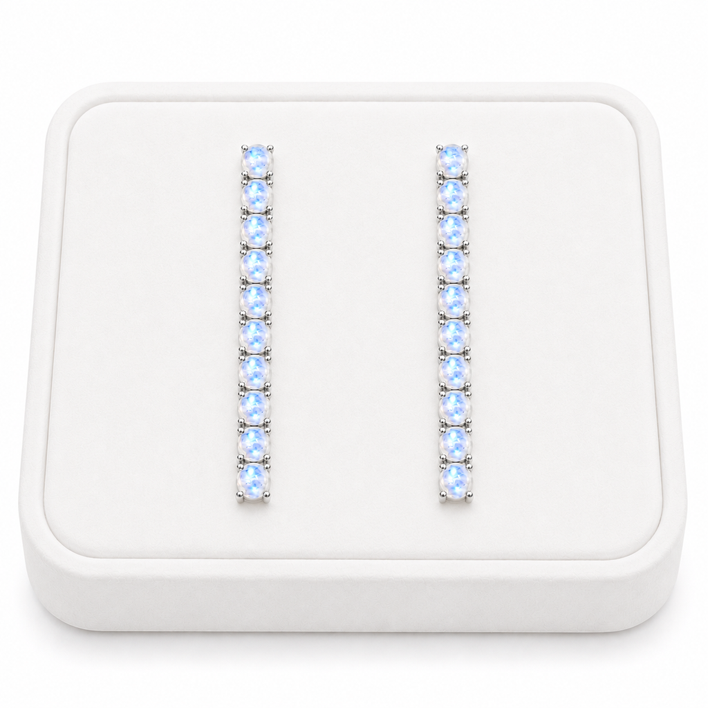Phimsera natural moonstone dangle earrings displayed on a flat white velvet jewelry tray against a completely white background