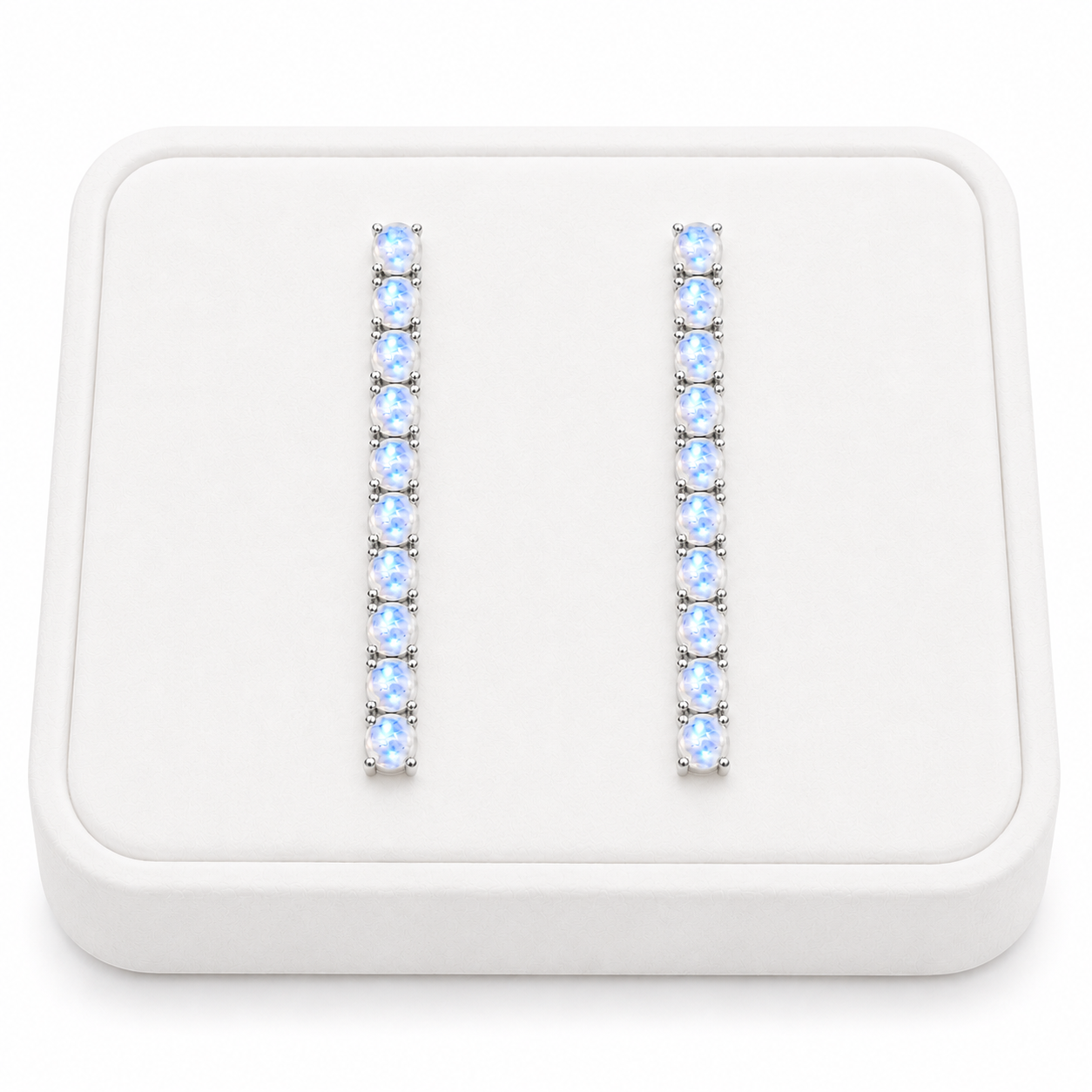 Phimsera natural moonstone dangle earrings displayed on a flat white velvet jewelry tray against a completely white background
