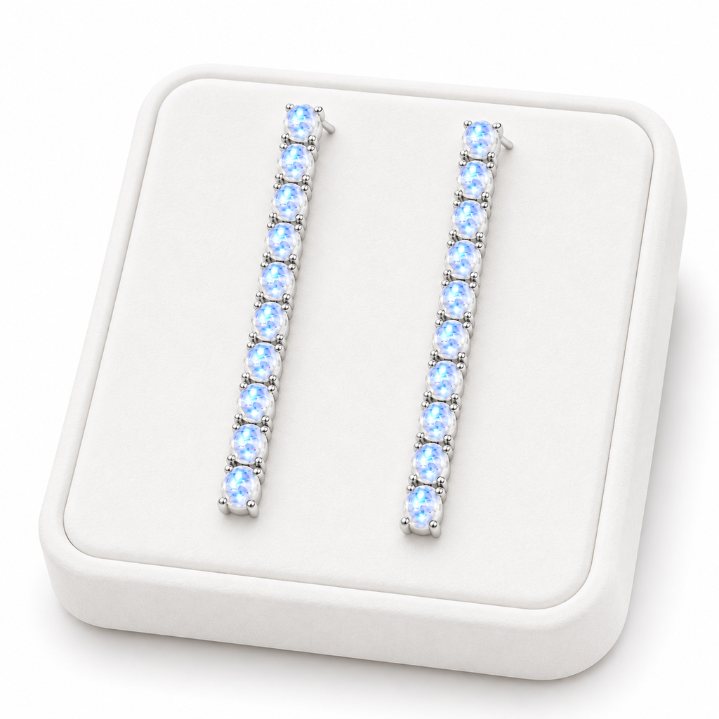 Phimsera natural moonstone dangle earrings displayed on a flat white velvet jewelry tray against a completely white background