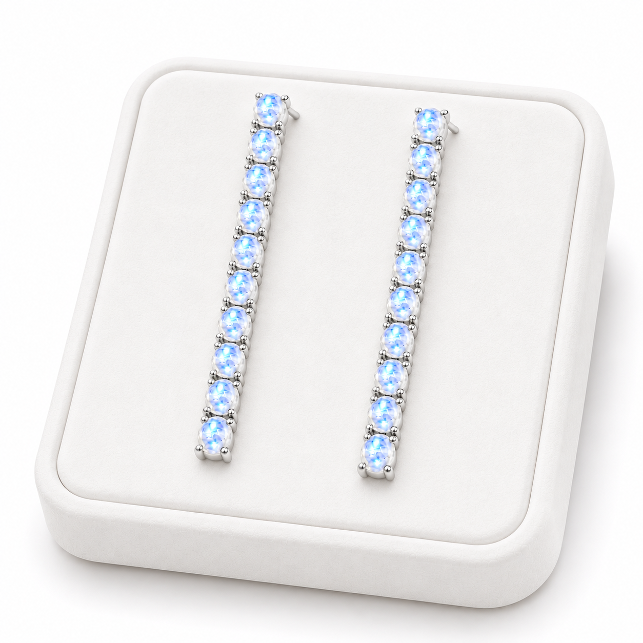 Phimsera natural moonstone dangle earrings displayed on a flat white velvet jewelry tray against a completely white background