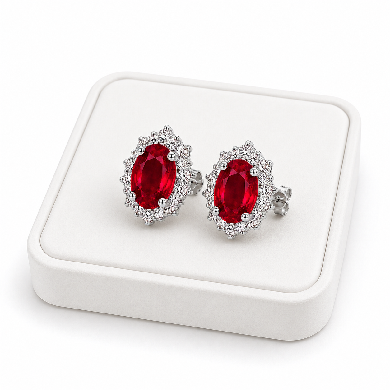 Natural ruby halo stud earrings displayed on white jewelry tray