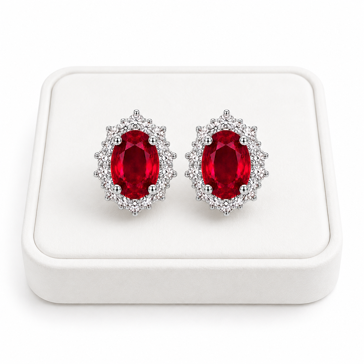 Natural ruby halo stud earrings displayed on white jewelry tray