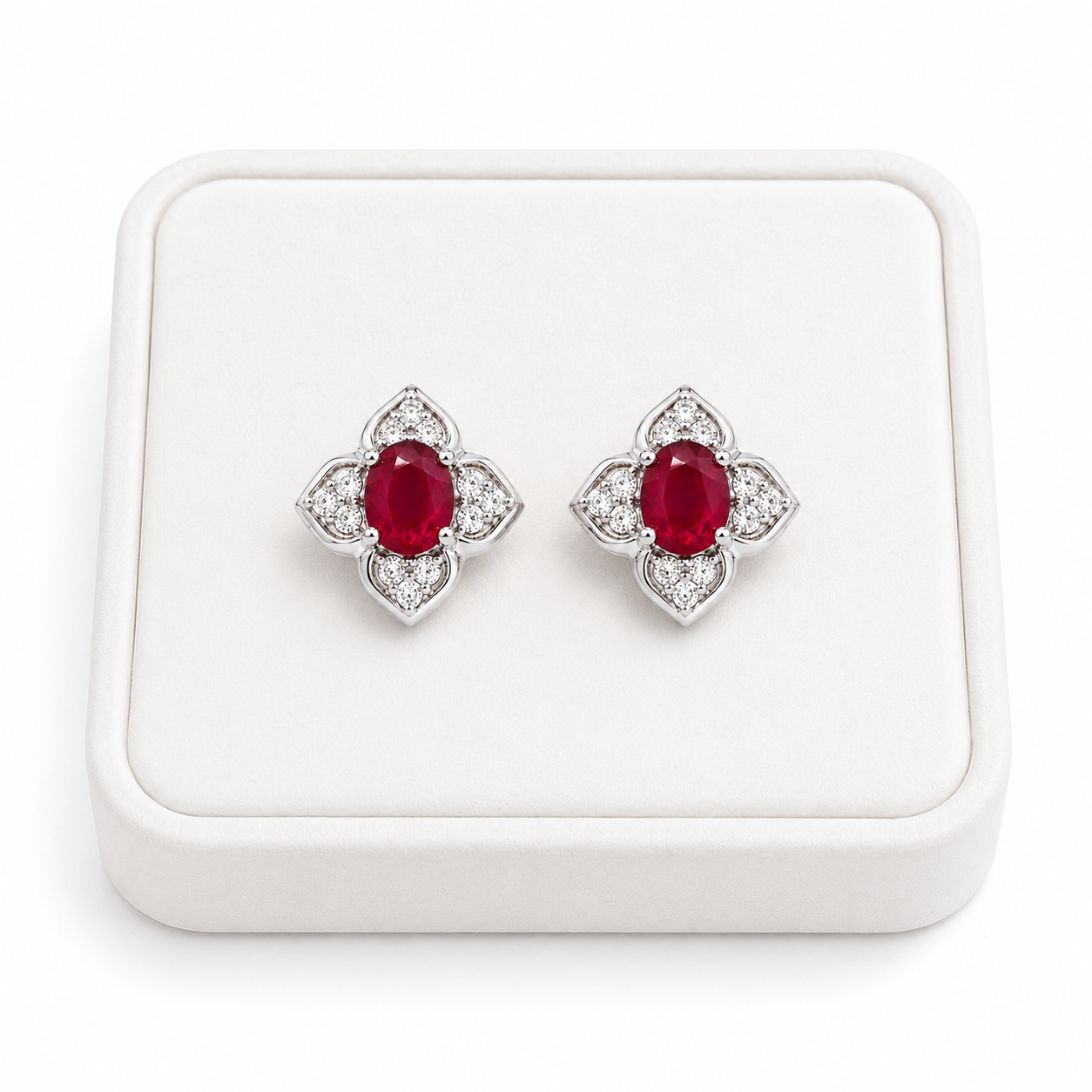Natural ruby floral stud earrings displayed on a white jewelry tray