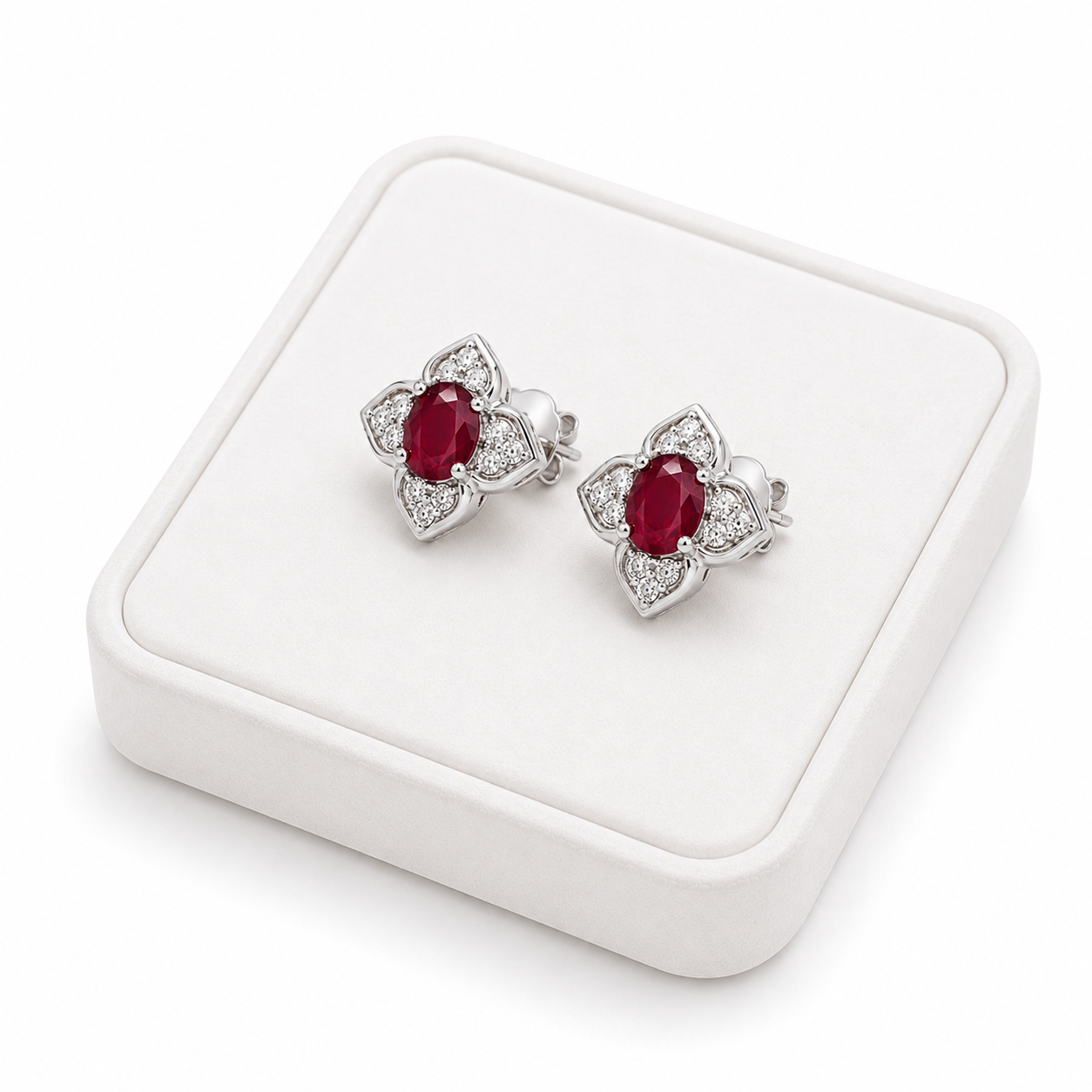 Natural ruby floral stud earrings displayed on a white jewelry tray