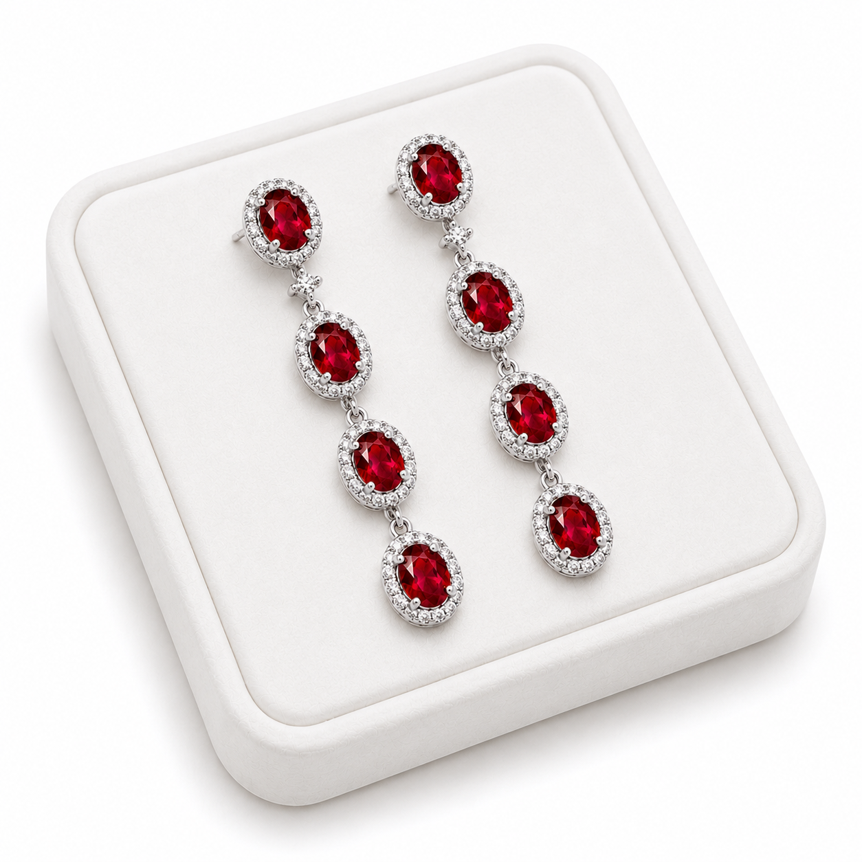 Natural ruby drop earrings displayed on white luxury jewelry tray