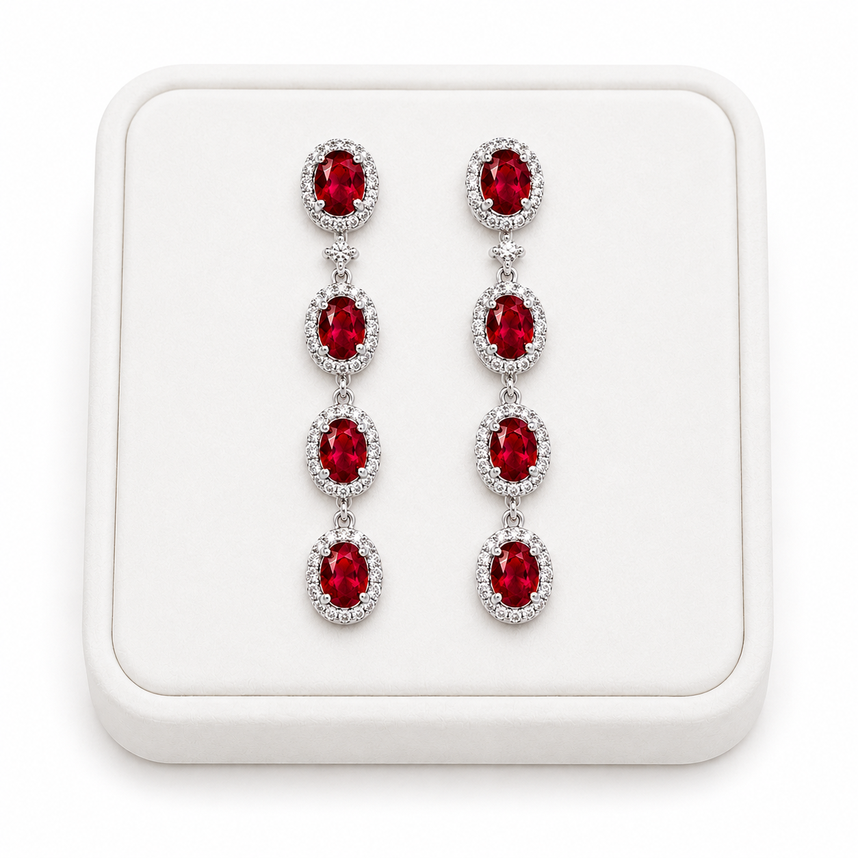 Natural ruby drop earrings displayed on white luxury jewelry tray