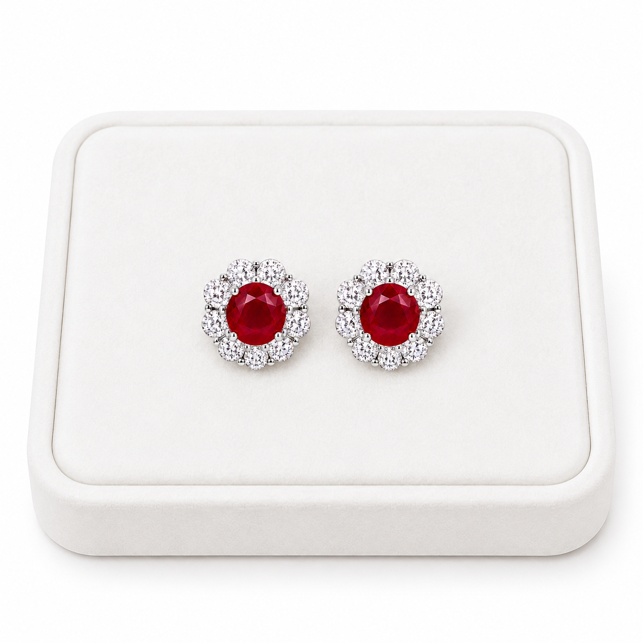 Natural ruby floral halo stud earrings displayed on white luxury jewelry tray