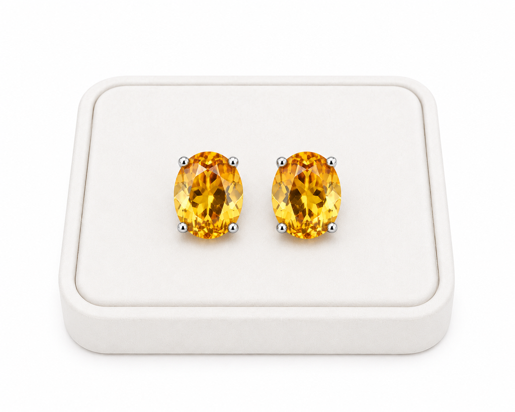 Natural oval citrine stud earrings displayed on white jewelry tray