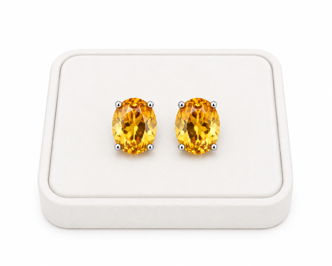 Natural oval citrine stud earrings displayed on white jewelry tray