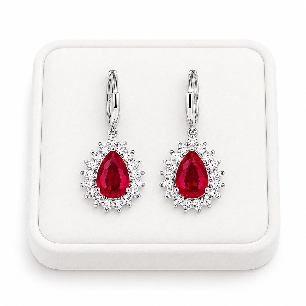 Natural ruby pear-cut drop earrings displayed on a white jewelry tray