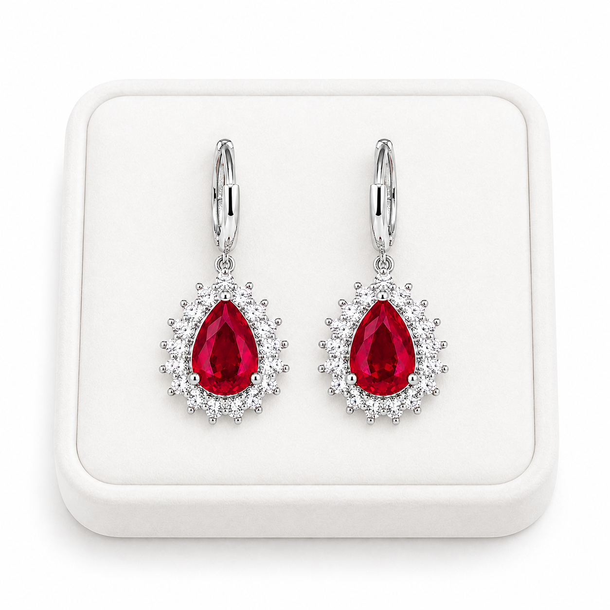 Natural ruby pear-cut drop earrings displayed on a white jewelry tray