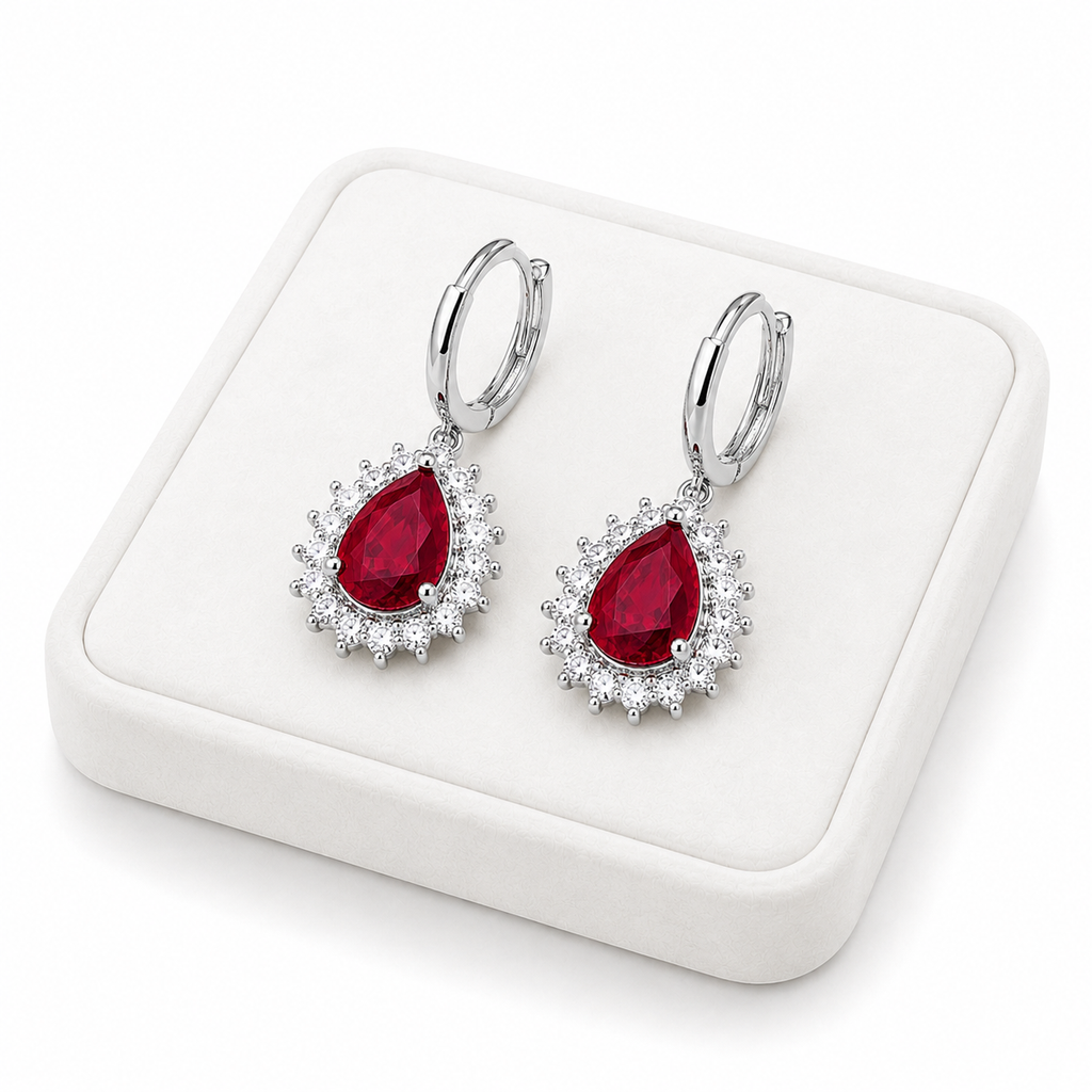 Natural ruby pear-cut drop earrings displayed on a white jewelry tray