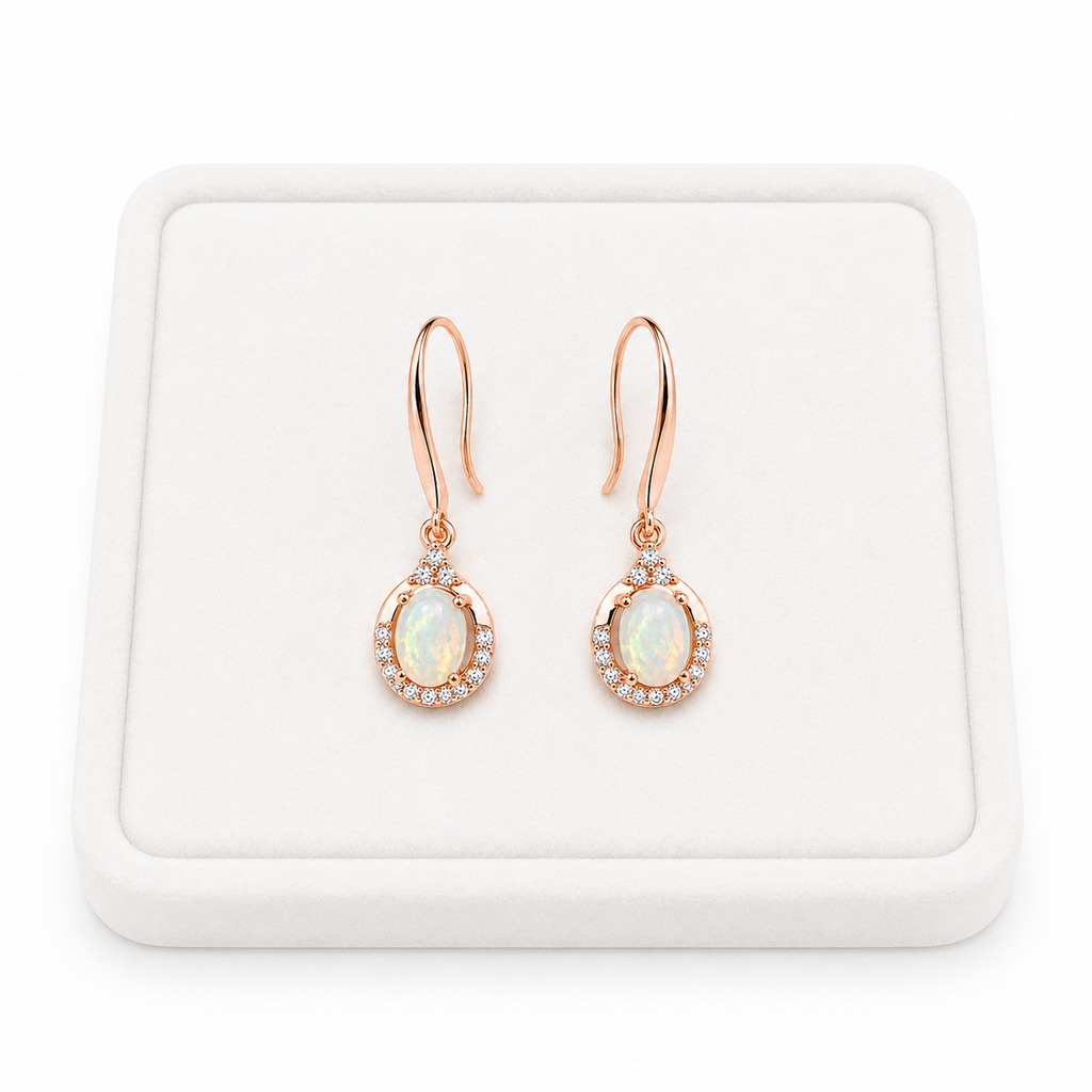 Natural 4x6mm fire opal dangle earrings displayed on a white jewelry tray with white background