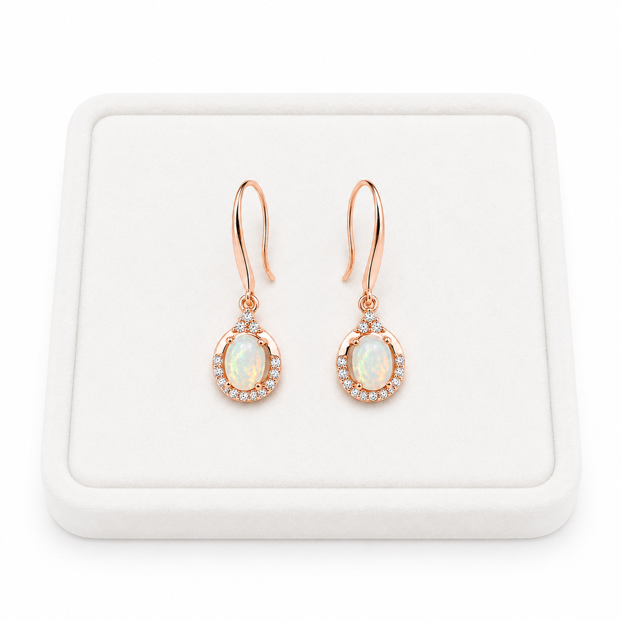 Natural 4x6mm fire opal dangle earrings displayed on a white jewelry tray with white background